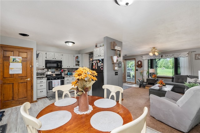 dining area with ceiling fan and light hardwood / wood-style flooring