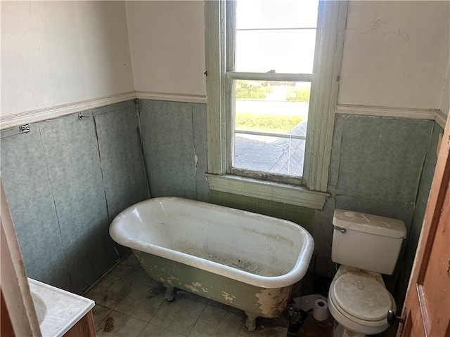 bathroom featuring a bath, tile patterned flooring, and toilet