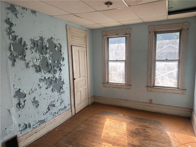 unfurnished room featuring hardwood / wood-style floors and a paneled ceiling