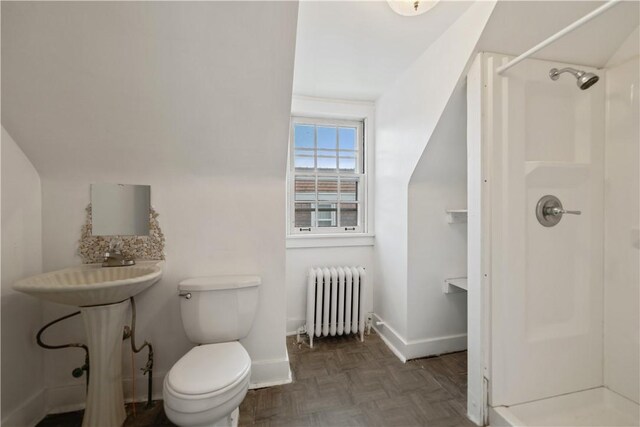 bathroom featuring a shower, radiator heating unit, parquet flooring, and toilet