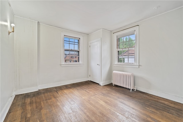 spare room featuring crown molding, wood-type flooring, and radiator