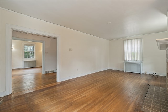 unfurnished room with hardwood / wood-style flooring and radiator