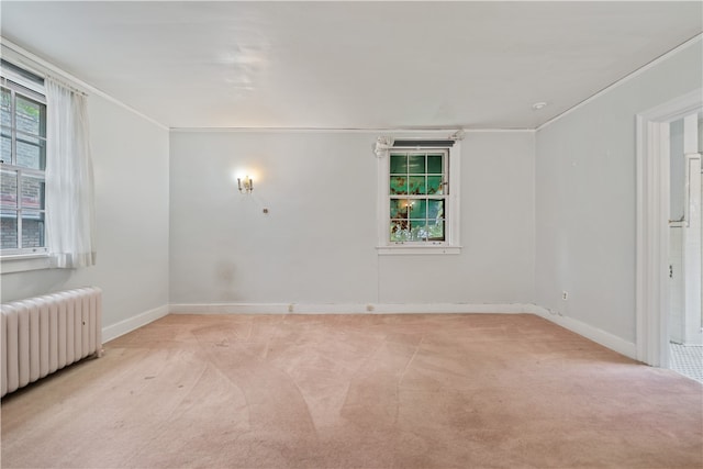 carpeted empty room featuring ornamental molding and radiator