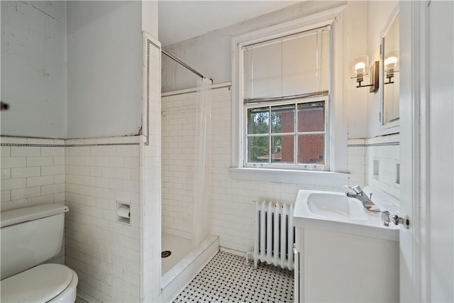 bathroom featuring toilet, tile walls, vanity, and radiator