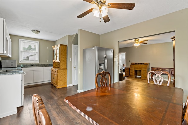 dining room featuring dark hardwood / wood-style flooring, sink, and ceiling fan