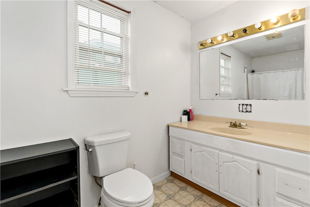 bathroom featuring toilet, a healthy amount of sunlight, vanity, and tile patterned floors