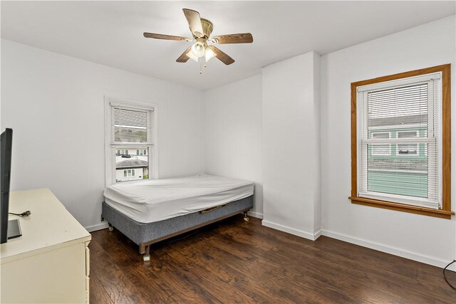 bedroom with multiple windows, hardwood / wood-style flooring, and ceiling fan