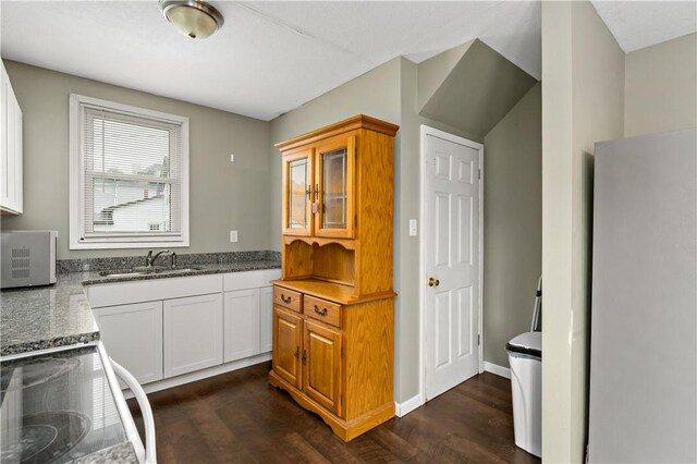 kitchen featuring sink, white cabinets, dark hardwood / wood-style floors, and stove