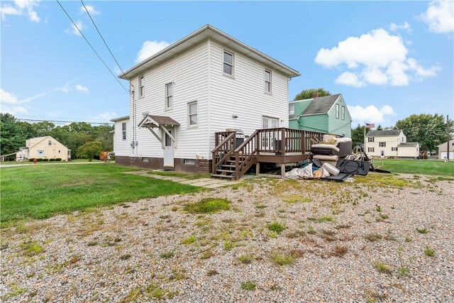 back of house with a wooden deck and a lawn