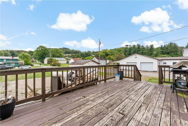 wooden deck featuring a garage and an outdoor structure