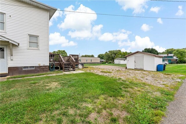 view of yard featuring a wooden deck and a storage unit