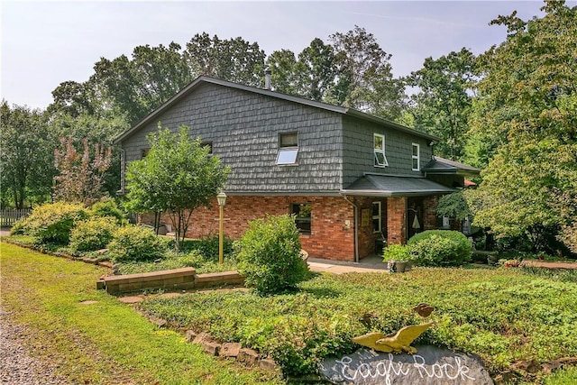 view of front of property with brick siding and a patio area