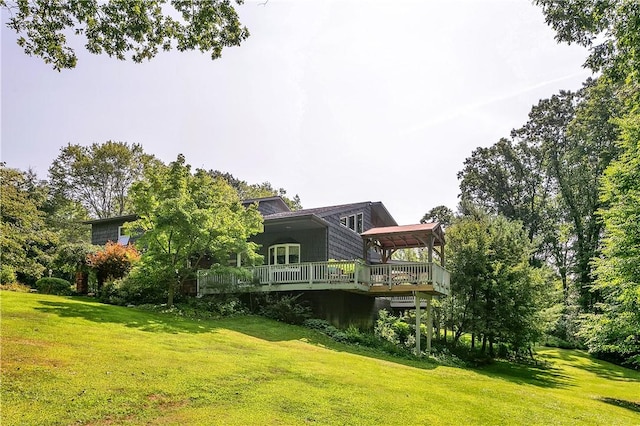 rear view of house with a lawn and a wooden deck