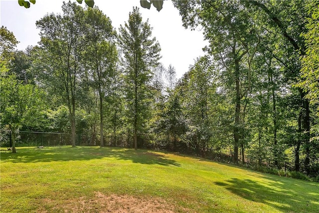 view of yard featuring fence and a wooded view