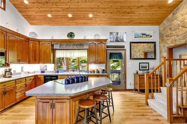 kitchen featuring wood ceiling, a kitchen breakfast bar, dishwasher, and a center island