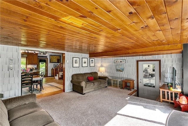 living area featuring stairway, carpet floors, and wood ceiling