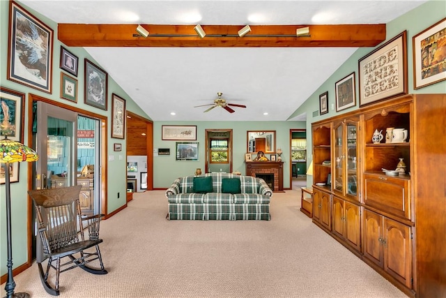 living room featuring lofted ceiling with beams, carpet floors, a fireplace, baseboards, and ceiling fan