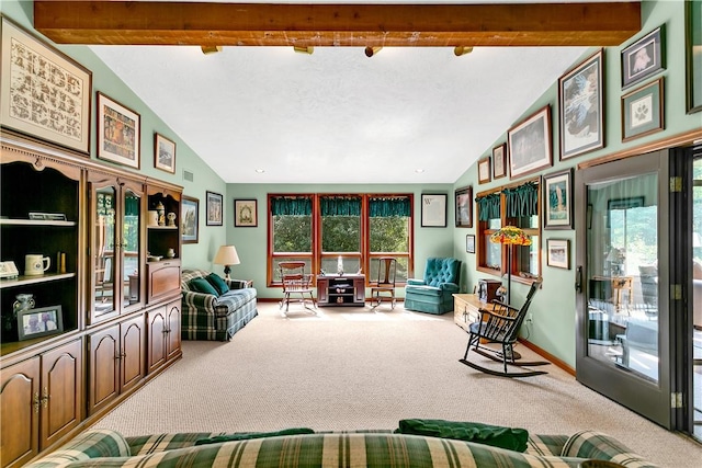 carpeted living room featuring lofted ceiling with beams, visible vents, baseboards, and a healthy amount of sunlight