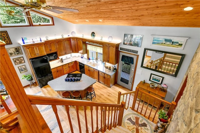 kitchen featuring lofted ceiling, a sink, ceiling fan, black appliances, and wooden ceiling