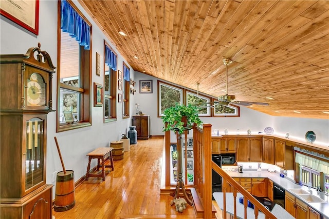 interior space with a sink, light wood-style floors, wooden ceiling, lofted ceiling, and ceiling fan