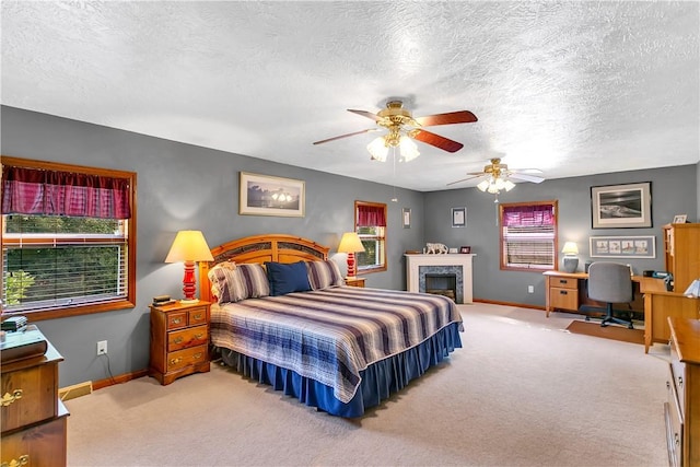 bedroom featuring a fireplace, baseboards, carpet floors, and a textured ceiling