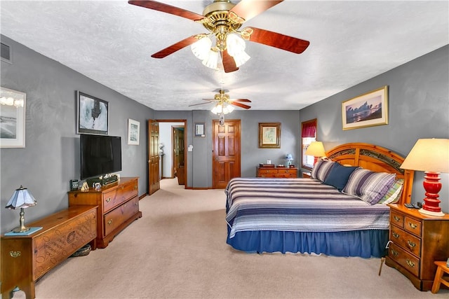 bedroom featuring a ceiling fan, visible vents, carpet floors, and a textured ceiling