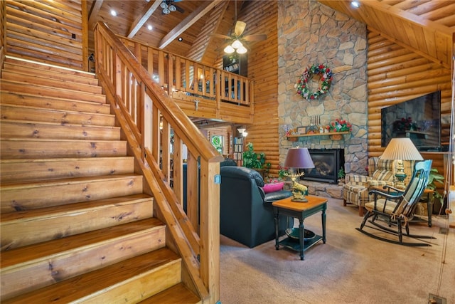 carpeted living room with wooden ceiling, high vaulted ceiling, ceiling fan, and log walls