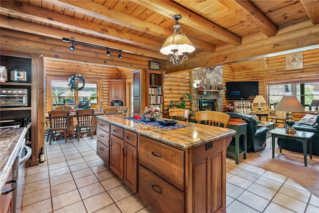 kitchen featuring light tile patterned floors, pendant lighting, wood ceiling, and a stone fireplace