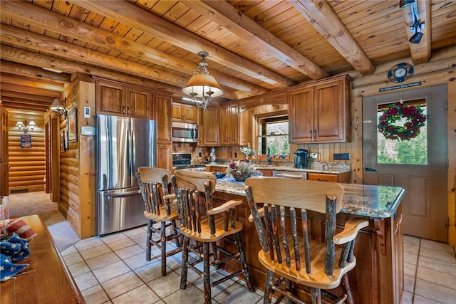 kitchen with appliances with stainless steel finishes, light tile patterned floors, rustic walls, wooden ceiling, and hanging light fixtures