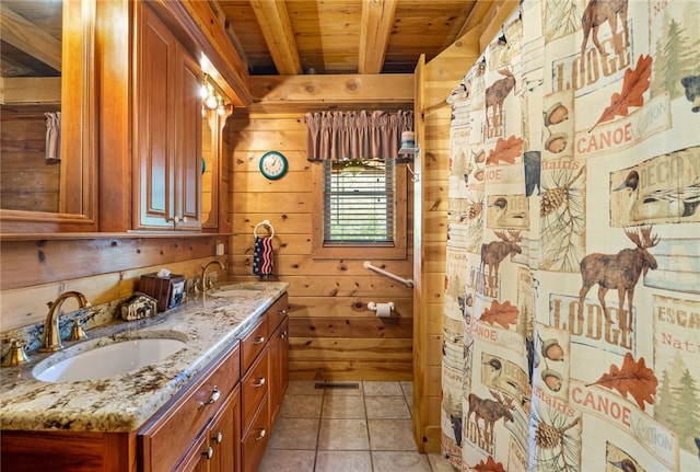 bathroom with wooden walls, double vanity, tile patterned floors, beam ceiling, and wooden ceiling