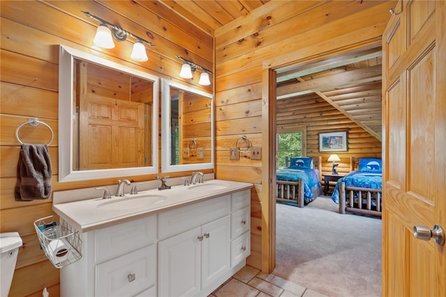 bathroom featuring dual vanity, toilet, wood ceiling, tile patterned flooring, and log walls