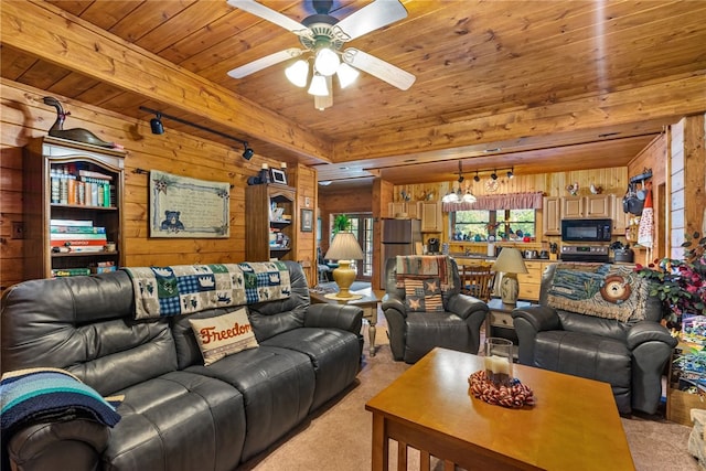 carpeted living room featuring ceiling fan with notable chandelier, wood ceiling, and wood walls