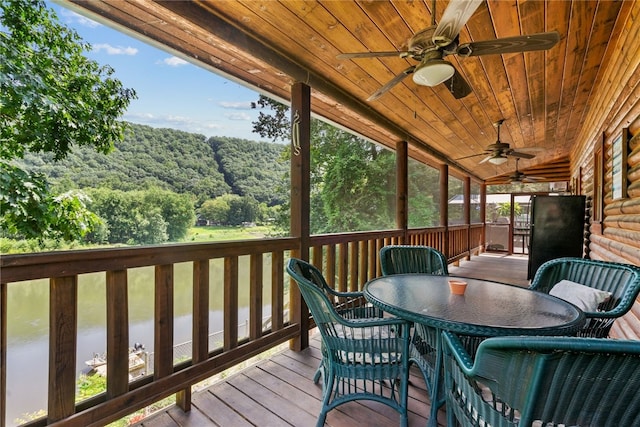 wooden terrace with ceiling fan and a water view