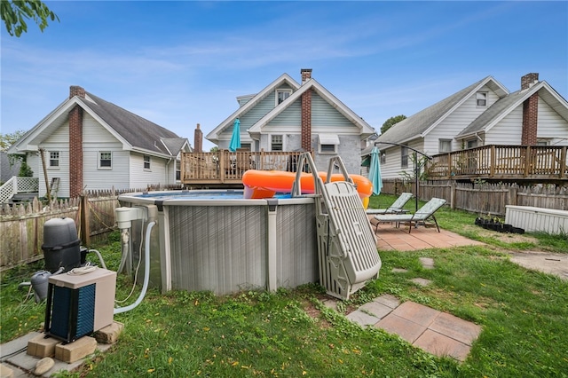 back of property featuring a swimming pool side deck, cooling unit, and a yard