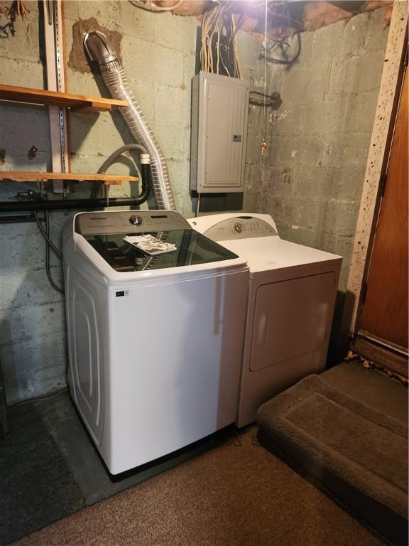 clothes washing area featuring electric panel and washer and clothes dryer