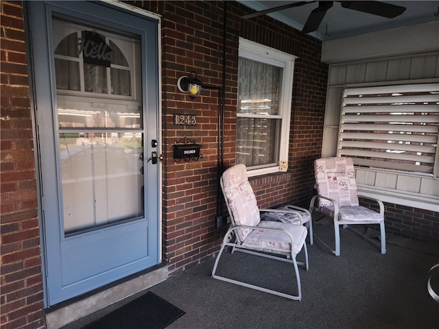 view of exterior entry with ceiling fan and covered porch