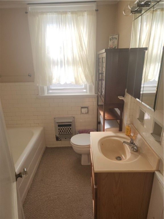 bathroom with vanity, heating unit, tile walls, toilet, and a tub