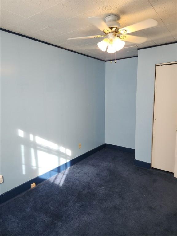 carpeted spare room featuring ceiling fan