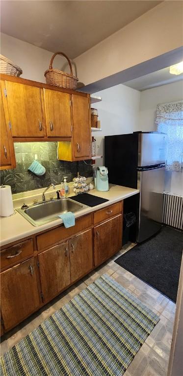 kitchen with stainless steel fridge, light tile patterned floors, sink, and tasteful backsplash