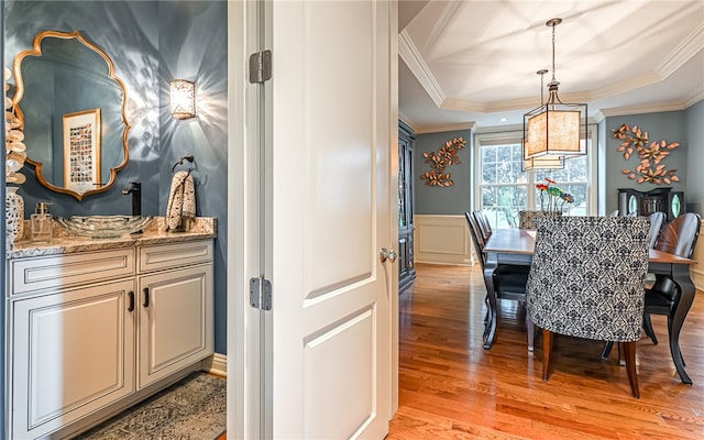 dining space featuring light wood-type flooring and crown molding