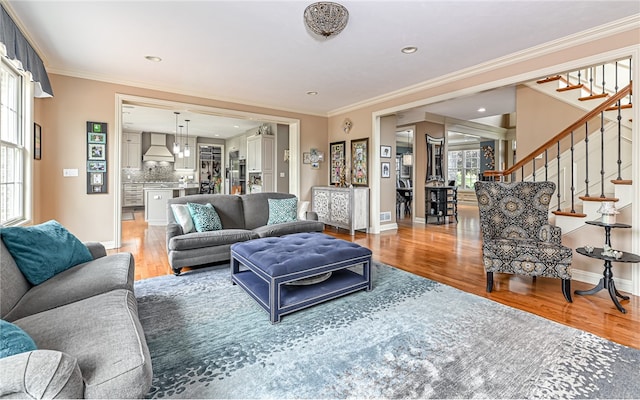 living room with wood-type flooring and ornamental molding