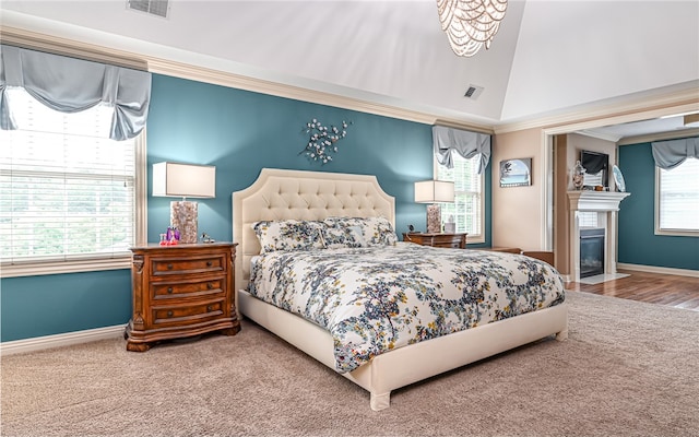 bedroom with hardwood / wood-style floors, lofted ceiling, crown molding, and a chandelier