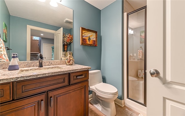 bathroom featuring tile patterned flooring, vanity, toilet, and an enclosed shower