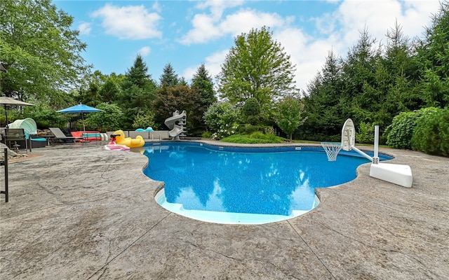 view of pool featuring a patio area and a water slide