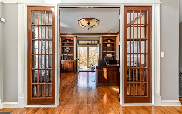 unfurnished office with wood-type flooring and ornamental molding