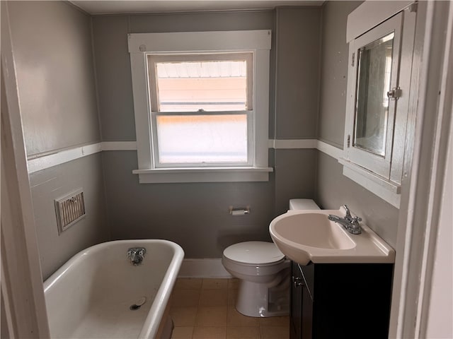 bathroom featuring tile patterned floors, a bathing tub, vanity, and toilet