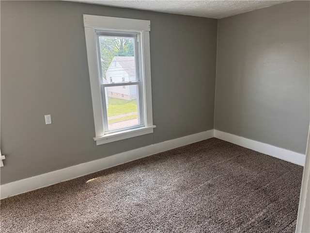 carpeted spare room featuring a textured ceiling