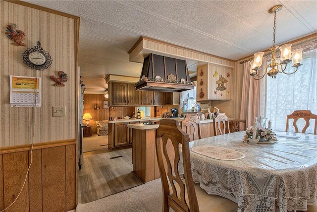 dining room featuring a textured ceiling, an inviting chandelier, and light colored carpet