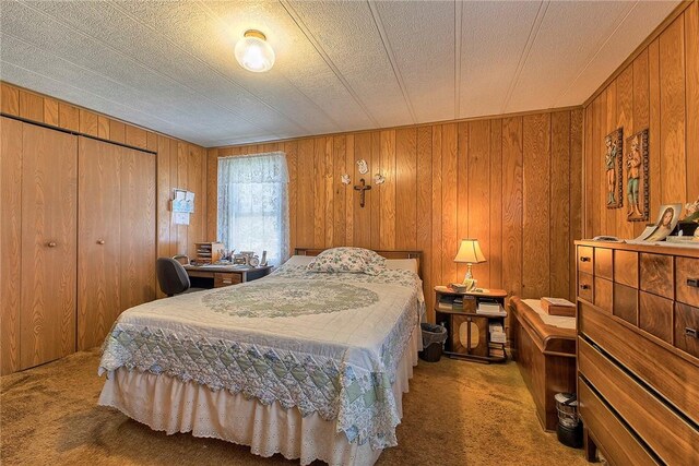 bedroom featuring wood walls and carpet