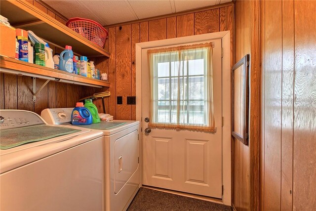 laundry area featuring washing machine and clothes dryer and wooden walls